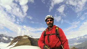 Mountain Climber filming his success achieving a life long ambition, Troublesome Glacier Chugach Mountains, South Central Alaska, USA,