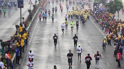 Mumbai, Maharashtra India - January 20th 2019 : Overview shot of a crowd of 100s of people running on the streets of Marine Drive for Tata Mumbai Marathon TMM2019 on a cold foggy winter morning.