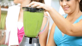 Healthy young Caucasian teenage girls home from gym nutritious fresh homemade vegetable juice drink with electric blender - Powered by Shutterstock - Get 15% off with code: PIKWIZARD15