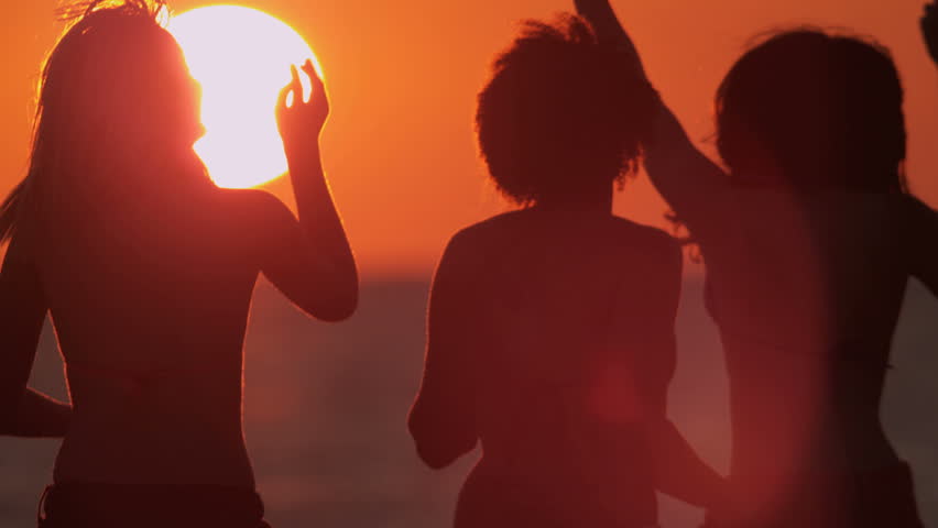 Young people in silhouette enjoying time together dancing having fun beach break at sunset shot on RED EPIC | Shutterstock HD Video #1023272101