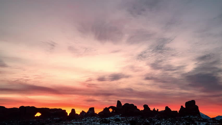 Colorful sunrise in Arches National Park in time-lapse viewing the North Window and Turret Arch.
