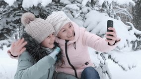 Video Call. The family communicates via video on the smartphone. Mother and daughter in the winter park are clicked on Skype.