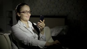 Manager woman speaks in an online video chat with the kids, sitting in a hotel late in the evening