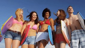 Laughing multi ethnic boy girl teenage college group holding body boards greeting friends using online social media
