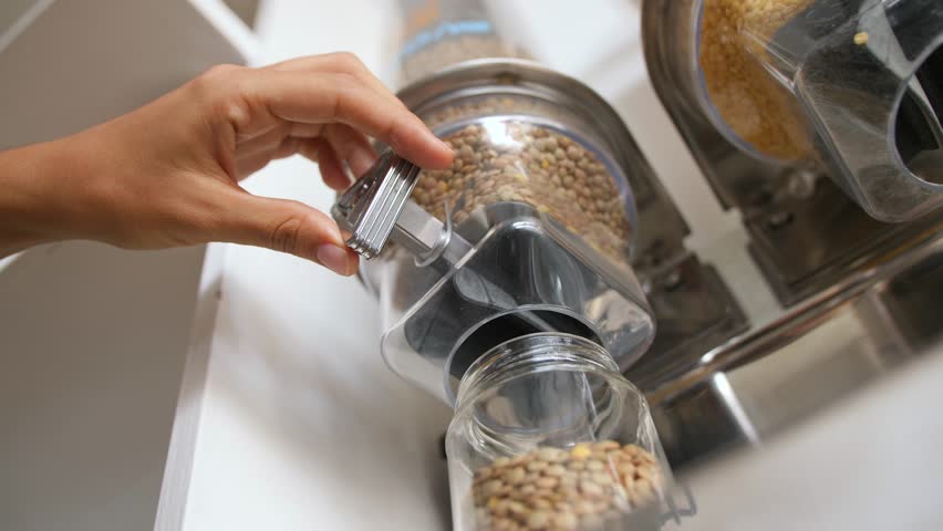 Vending Machine with Beans and Grains in Zero Waste Shop. Young Vegan Woman Pours Lentils in Glass Jar. No plastic Conscious Minimalism Lifestyle Concept. 4K Slowmotion. Royalty-Free Stock Footage #1023286885