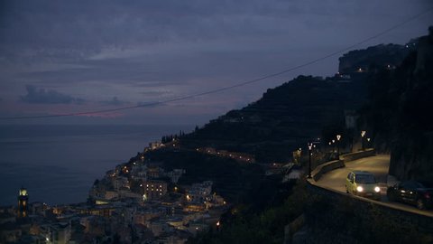 View of the Amalfi Coast with streets and buildings and homes, with night time dark light. Wide shot on 8k helium RED camera.