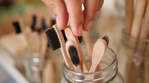 Young Mixed Race Woman Choosing Bamboo Eco Friendly Biodegradable Toothbrush in Zero Waste Shop. No plastic Conscious Minimalism Vegan Lifestyle. Reduce Reuse Recycle 4K Slowmotion Concept.