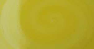 Close video of potassium gluconate tablets being poured onto a bright yellow plate.