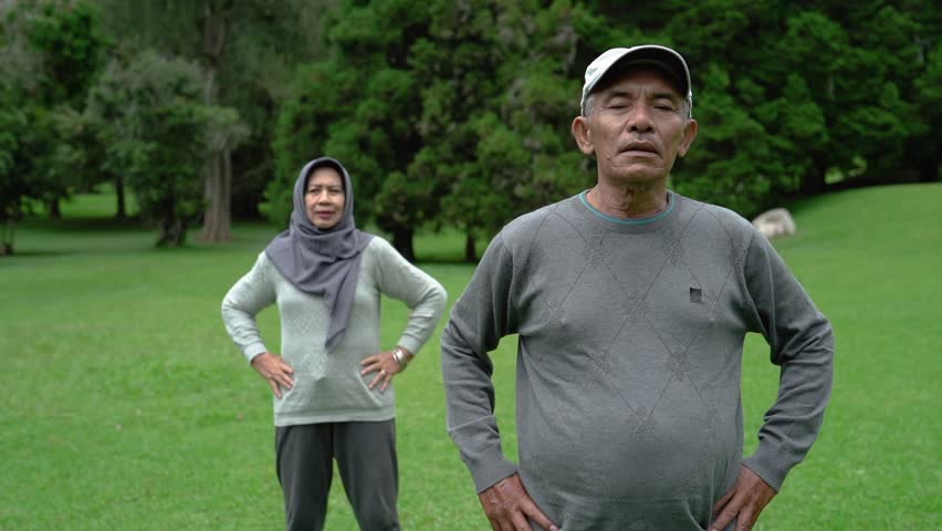 portrait of asian muslim senior couple exercising together in the park