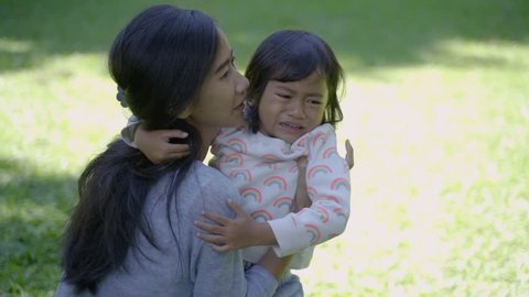 portrait of asian mother telling her upset daughter to stop crying