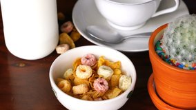 Pouring milk into a bowl of Corn Flakes and Froot  Loops for delicious breakfast