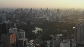 Aerial scene of Fly down over center of bangkok, lumpini park and city building in morning, Thailand, 4k video
