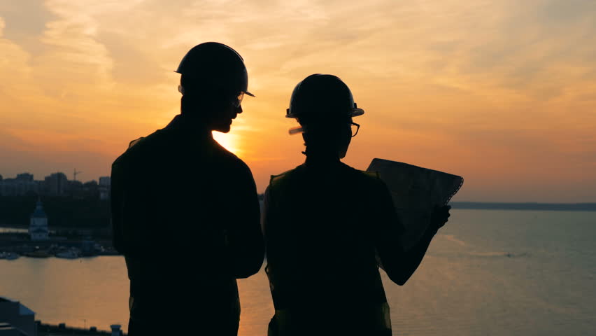 Workers talk, standing on a sunset background, back view. Royalty-Free Stock Footage #1023304042