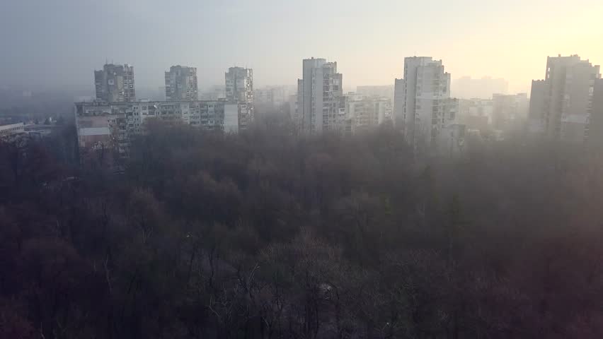 Flying over a concrete living apartment area in east Europa with many birds flying around the drone