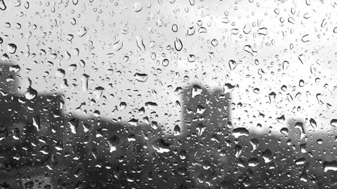 rain drops on windowpane against buildings