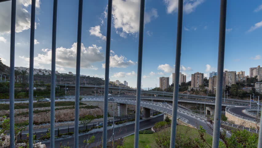 up pan from behind a fence of roads interchange, Haifa, Israel.
