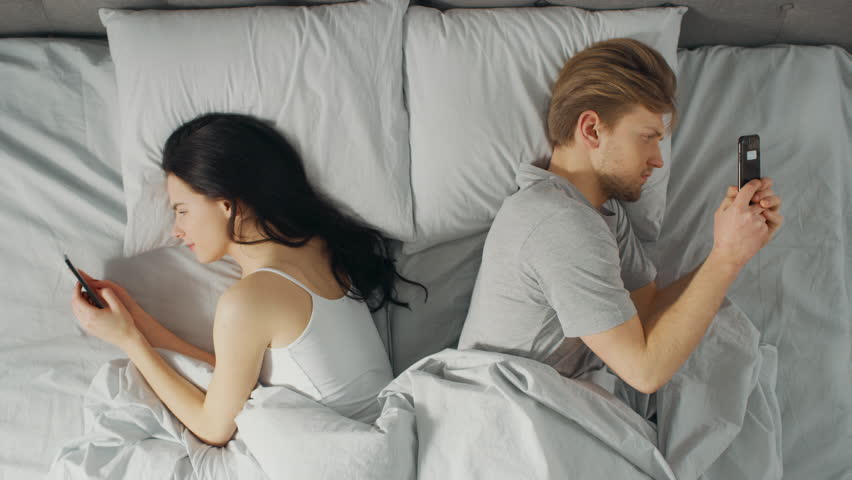 Alienated Millennial Young Couple in the Bed, Young People Turn Away From Each other Using Smartphones, Browsing Through Social Networks and Not Talking to Each Other. Top Down Camera Shot | Shutterstock HD Video #1023333724