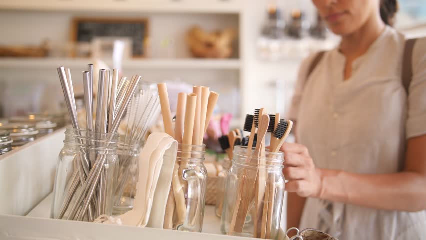 Young Mixed Race Woman Choosing Bamboo Eco Friendly Biodegradable Toothbrush in Zero Waste Shop. No plastic Conscious Minimalism Vegan Lifestyle. Reduce Reuse Recycle 4K Slowmotion Concept. Royalty-Free Stock Footage #1023335146