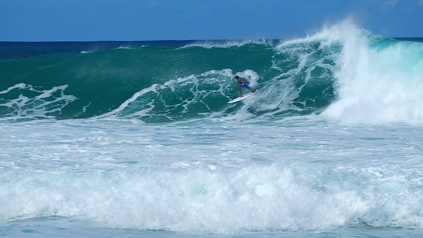 Brave man surfs inside the huge barreling powerful wave on the North Shore of Oahu, Hawaii