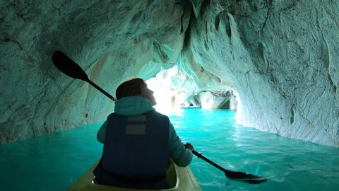 Woman paddles kayak and explores Marble Cave located near the town of Puerto Rio Tranquilo on General Carrera Lake. Chilean Patagonia