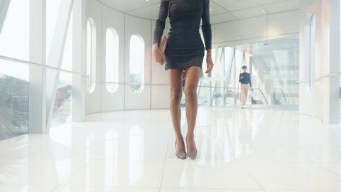 Beautiful slender Asian girl ladyboy walks along a spacious light corridor with stained glass windows. looking at the camera and smiling. Thai transgender model.