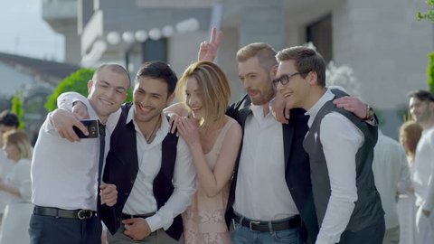 Happy cool friends , groomsmen , groom and bride posing and taking selfie photo during wedding party . Shot on RED EPIC DRAGON Cinema Camera in slow motion.