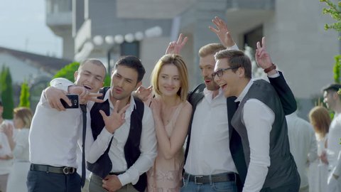 Happy cool friends , groomsmen , groom and bride posing and taking selfie photo during wedding party . Shot on RED EPIC DRAGON Cinema Camera in slow motion.