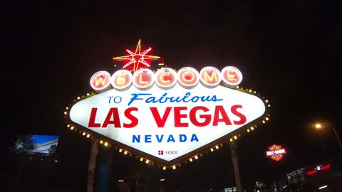 Las Vegas, Nevada, United States - September 20, 2018: the popular Las Vegas neon Sign. Welcome to Fabulous Las Vegas Nevada illuminated by night. Harley Davidson sign on background.