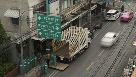 Bangkok/ Thailand- November 2018: Time-lapse of traffic and propane being loaded into the back of a truck