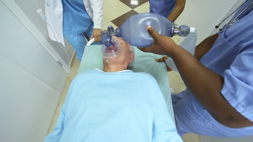 High angle dolly shot of ER nurses and female doctor pushing gurney along hospital corridor and administering oxygen and IV fluids to elderly patient, a Healthcare Video by Pressmaster