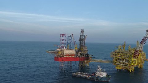 KELANTAN, MALAYSIA - JANUARY 25, 2019: Supply vessel with offshore jack-up drilling rig and gas production platform. An FSO (Floating, Storage and Offloading) vessel also can be seen in this footage.