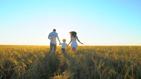 happy family outdoors running on wheat field with little boy. Mother, father and son kid child having fun on summer day, enjoying nature together. health love travel summertime happy holiday happiness