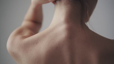 female shoulders close up. girl touches her neck and shoulders