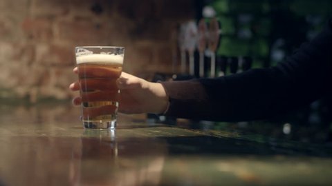 Bartender Serving A Glass Of Beer At The Bar Counter