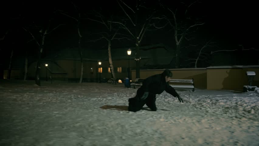 A man in a black cloak fell in the snow. 4k