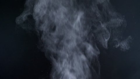 Close-up shot of great vapouring smoke with sprays flying on black background.