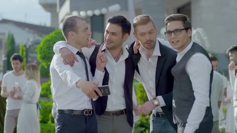 Happy cool friends , groomsmen , groom and bride posing and taking selfie photo during wedding party . Shot on RED EPIC DRAGON Cinema Camera .