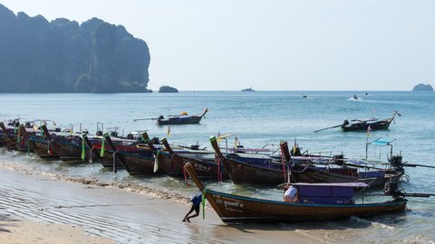 AO NANG, KRABI, THAILAND - JANUARY 21, 2019: Time lapse of Thai long tail boats in water on beach