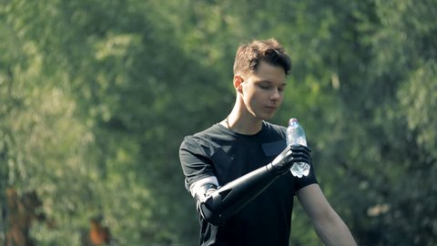 Prosthetic hand holding a bottle. Human with a robot arm.