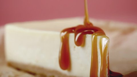 Close-up of cheesecake is poured sweet sauce. Frame. Appetizing cheesecake artfully watered with sweet caramel. Concept of desserts