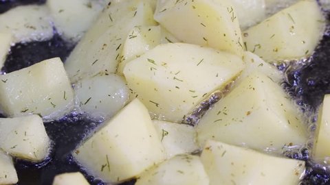 Potatoes fried in a pan close-up and stirred