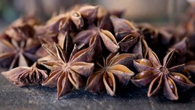 Close up footage of star anise spice on wooden board. Selective focus. Tracking shot.