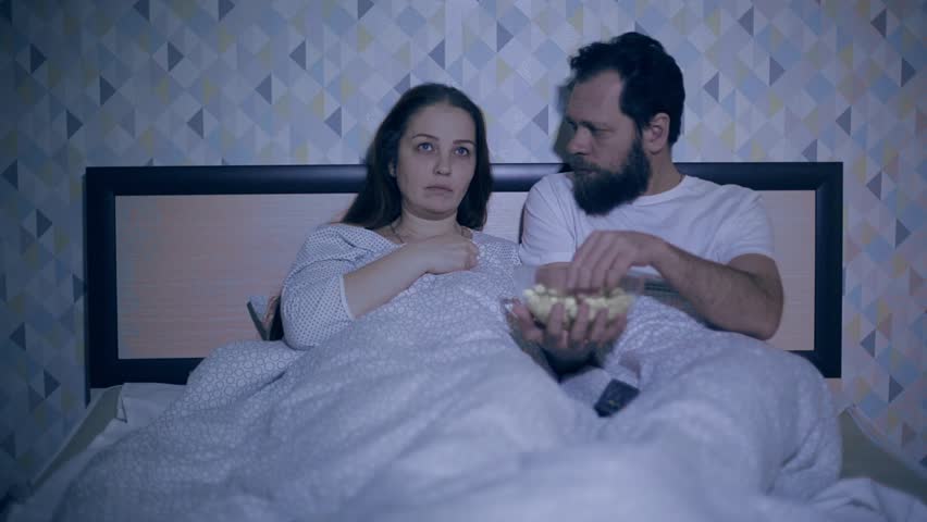 Husband and wife lie in bed late at night and watch television | Shutterstock HD Video #1023398443