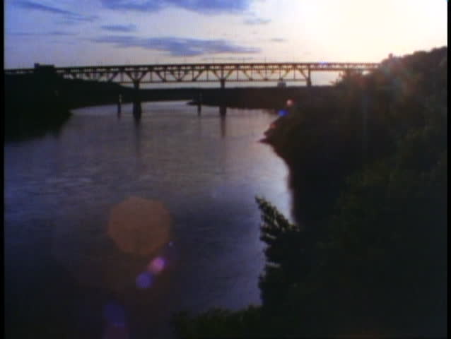 EDMONTON, ALBERTA, 1990, Sunset view with river and bridge, wide shot