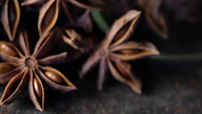 Close up footage of star anise spice on wooden background. Selective focus. Panning to the right.
