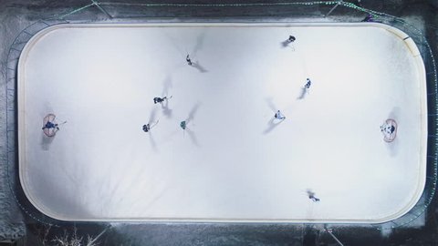 Playing Ice Hockey on Ice Rink. Aerial Vertical Top-Down View. Static Drone Shot