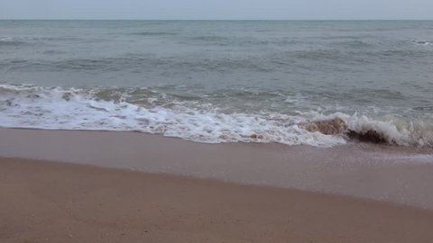 Sea waves run on the sandy shore. Thailand 