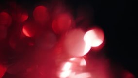 Magical red light leaks on the left side of the frame alternately flicker in the dark, 4k footage.