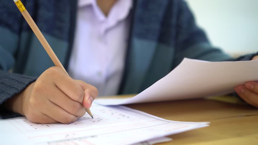 School / university Students hands taking exams, writing examination room with holding pencil on optical form answers paper sheet on desk doing final test in classroom. Education assessment Concept Royalty-Free Stock Footage #1023463075