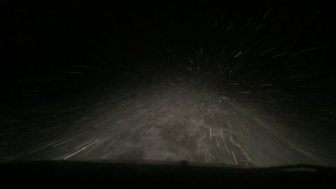 night roadl in heavy snow with strong blizzard in moving car